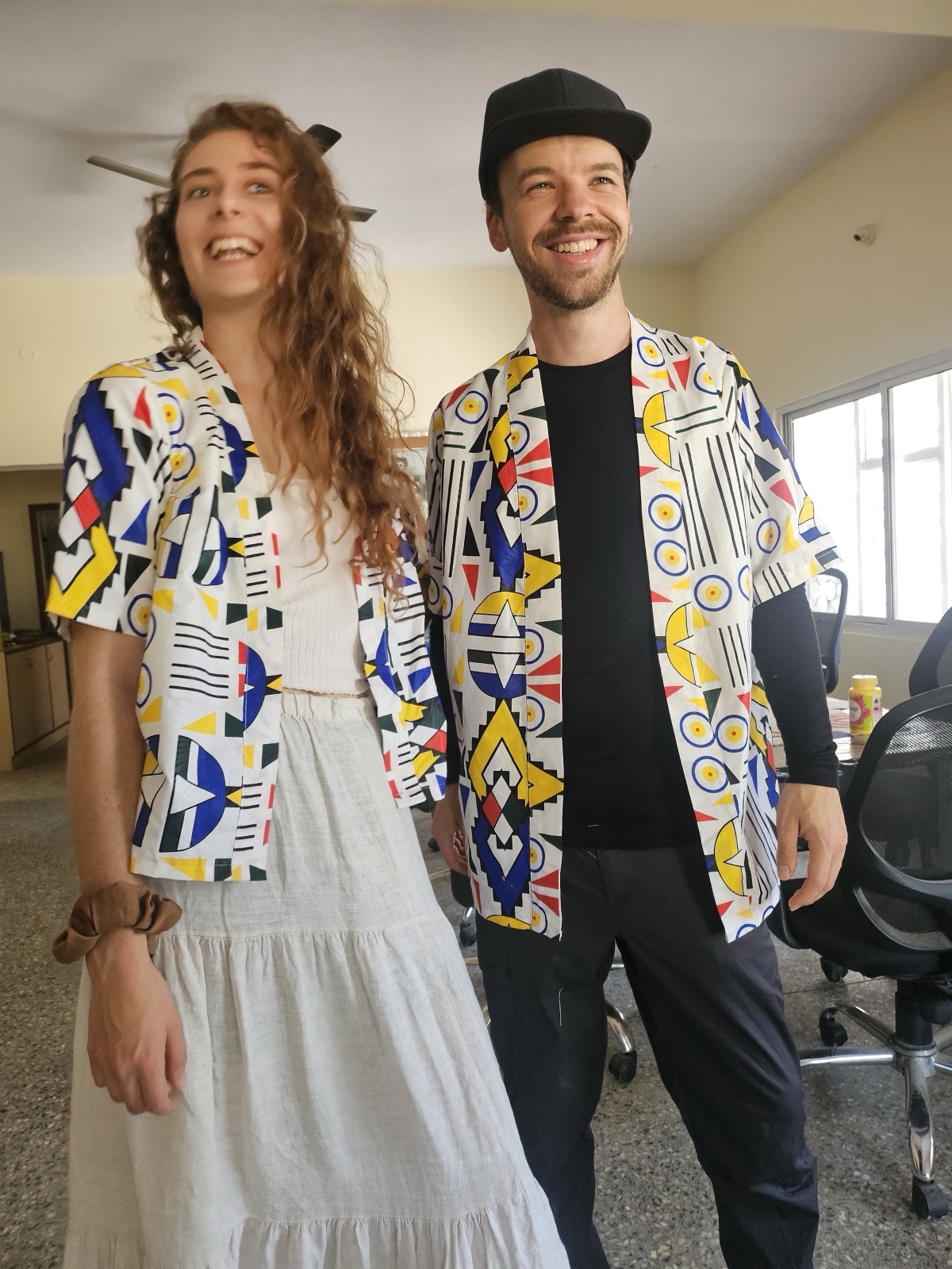 Two people laughing in matching geometric shirts