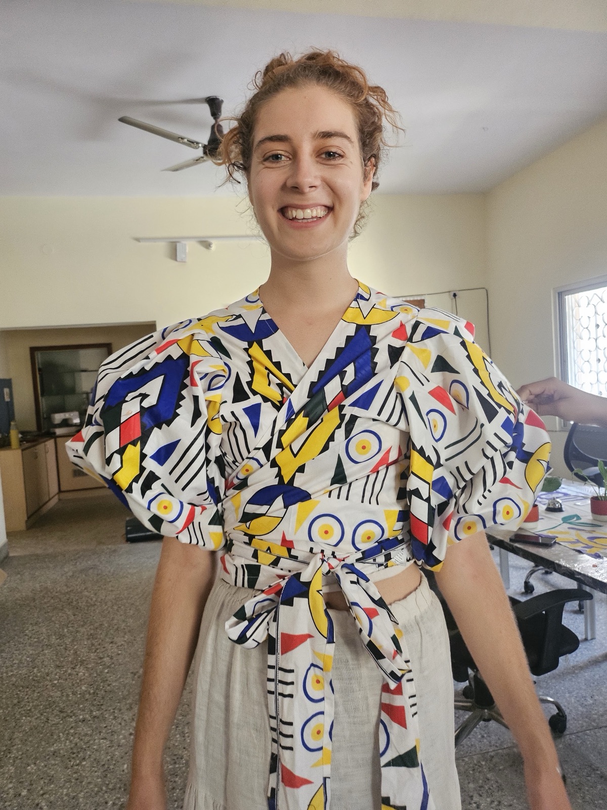 A smiling model in the geometric wrap top