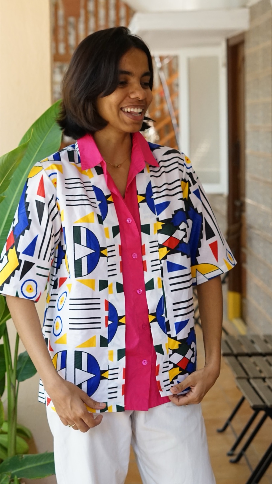 A short-sleeved geometric shirt over a pink shirt