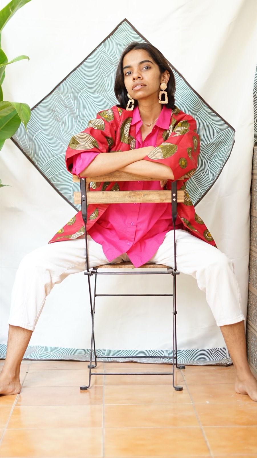 The short kimono worn over a pink shirt, model seated astride a chair