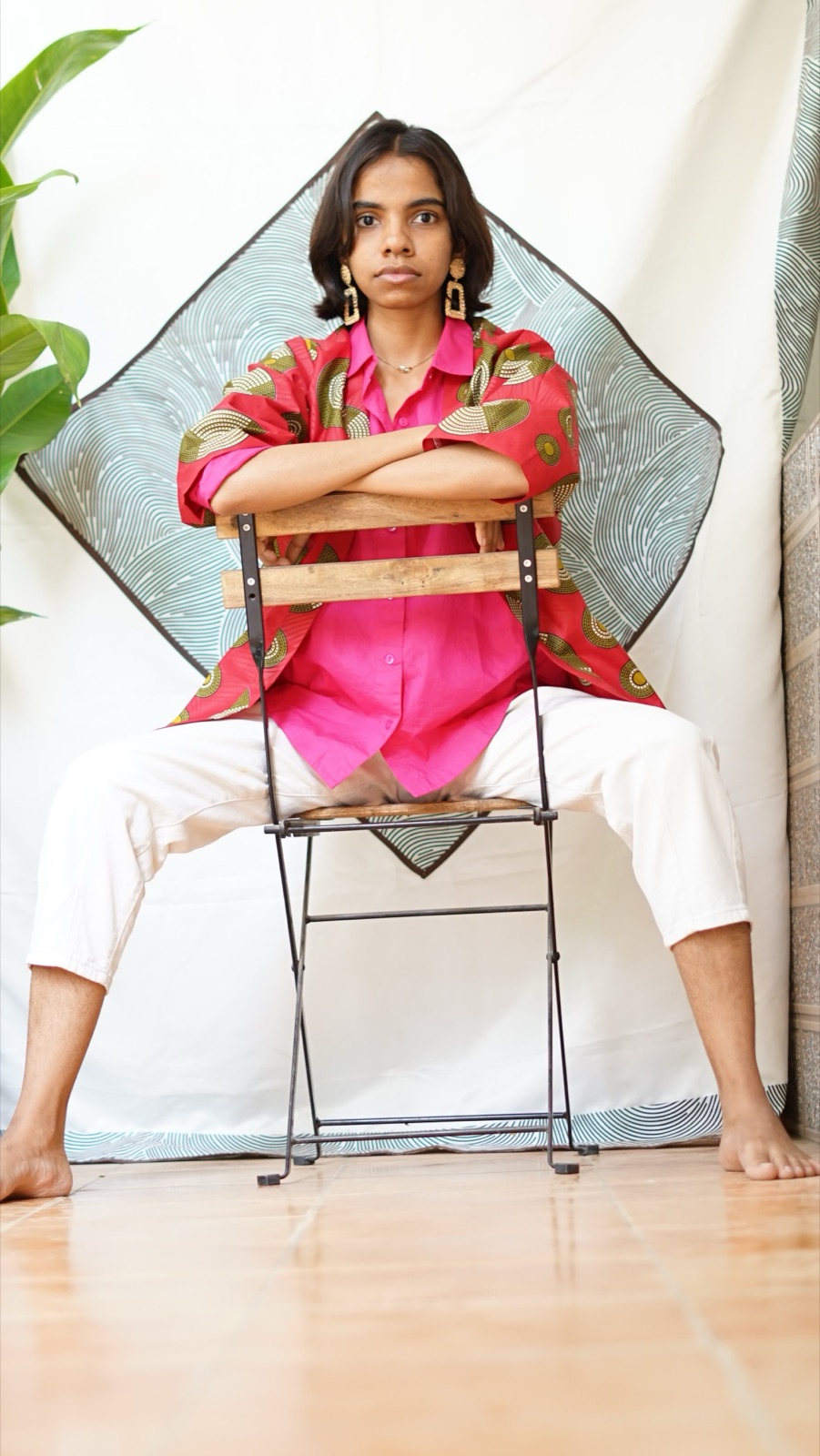 The short kimono, arms crossed over the chair back